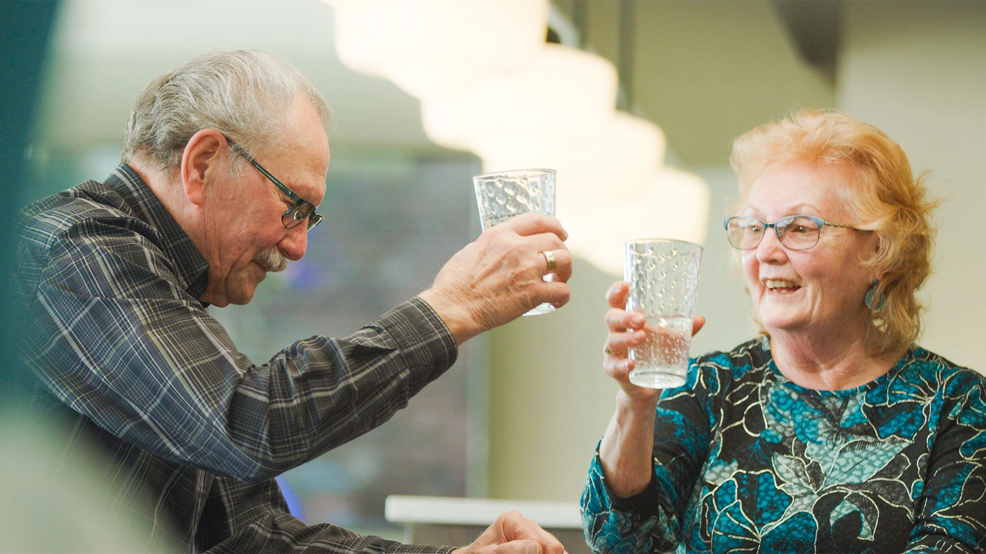 Seniors raising a toast with glass of water